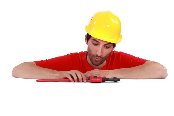 Plumber looking at his tool surprisingly — Stock Photo, Image