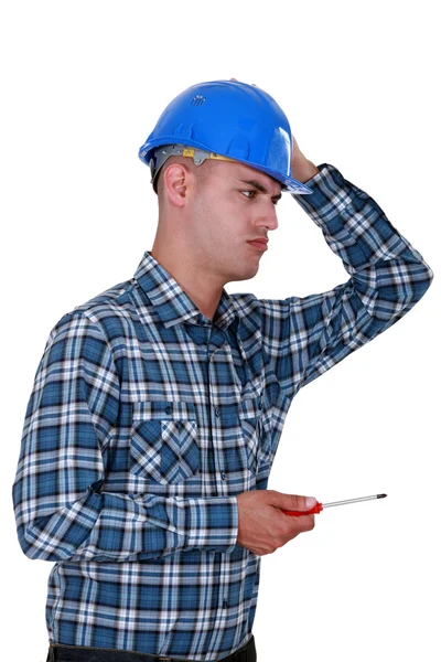 A dubious handyman with a screwdriver. — Stock Photo, Image