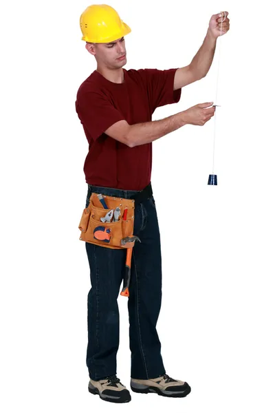 Řemeslník drží nástroj pro měření řetězec — Stock fotografie