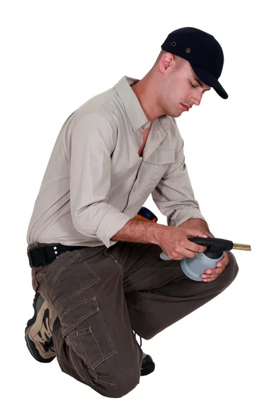 Um trabalhador manual examinando uma tocha de soldagem . — Fotografia de Stock