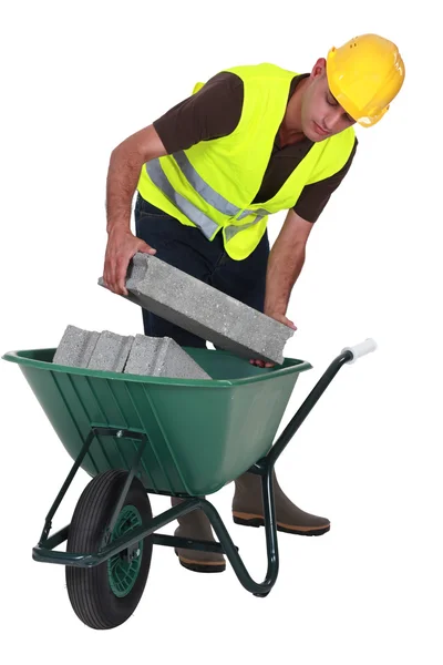 Trabalhador colocando blocos de cimento em um carrinho de mão — Fotografia de Stock