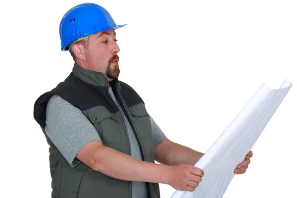 Surprised tradesman looking at a blueprint — Stock Photo, Image