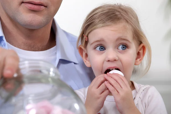 Lilla flickan äta marshmallows — Stockfoto