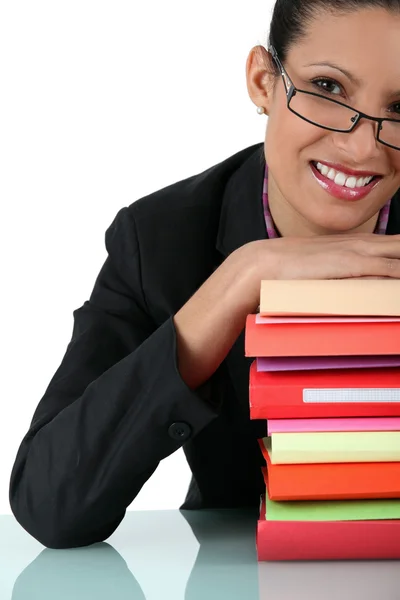 Mulher sorrindo com pilha de livros — Fotografia de Stock