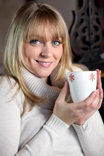 Portrait of a blonde woman drinking a hot drink — Stock Photo, Image