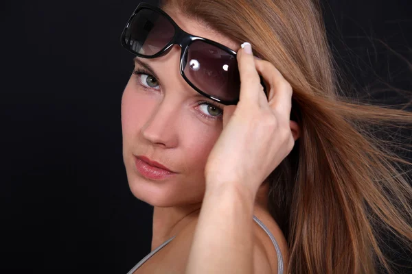 Portrét ženy, zvýšení její sluneční brýle — Stock fotografie