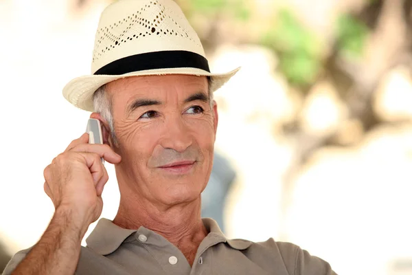 Een volwassen man op de telefoon tijdens een mooie zomerdag. — Stockfoto