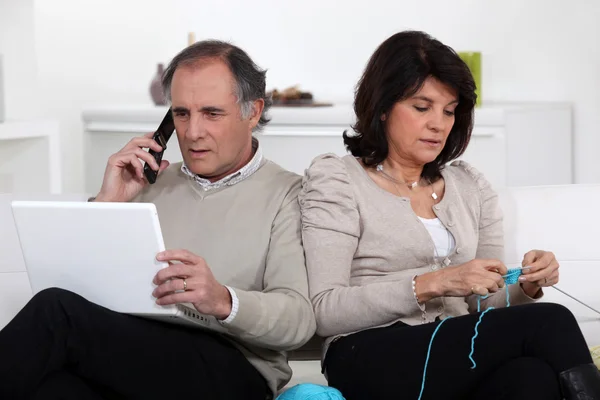 Man on phone and woman knitting at home — Stock Photo, Image