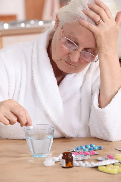 Старшая женщина принимает свои таблетки — стоковое фото