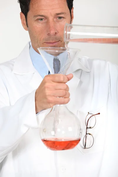 Um cientista trabalhando com frascos em um laboratório . — Fotografia de Stock