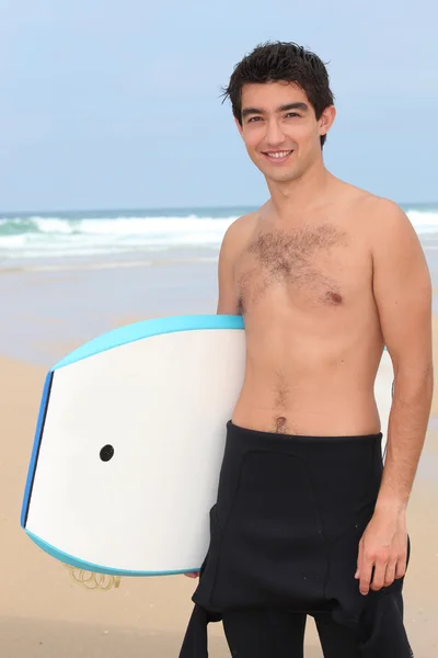 在海滩上的年轻男子要做 bodyboard — 图库照片