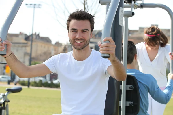 Ένας άνδρας κάνει fitness με δημόσιο γυμναστήριο μηχανή — Φωτογραφία Αρχείου