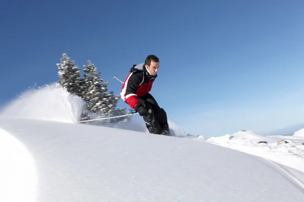 Человек спускается с горы на лыжах — стоковое фото