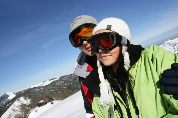 Um casal caminhando em montanhas nevadas — Fotografia de Stock