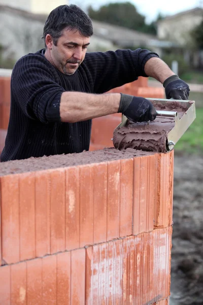 Mason carefully pouring cement — Stock Photo, Image