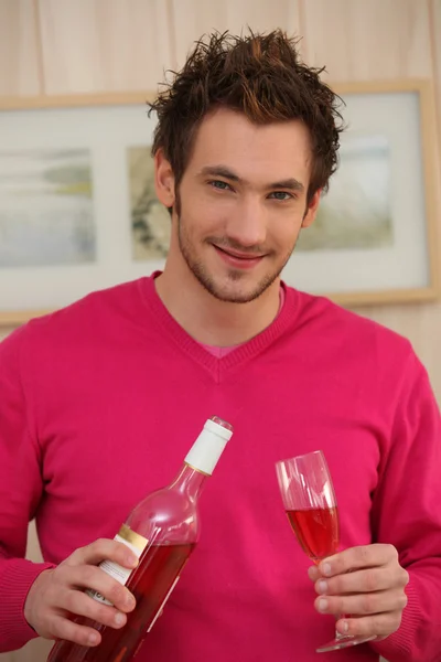 Un giovane che versa il vino in un bicchiere — Foto Stock