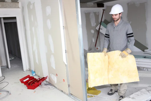 Costruttore che trasporta isolamento della parete — Foto Stock