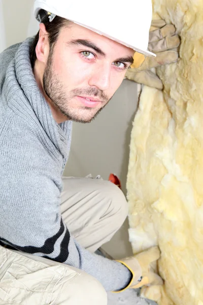 stock image Man pushing wall insulation into place