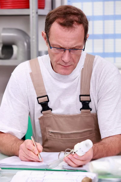 Handwerker in seinem Büro, der ein Produkt beschreibt — Stockfoto