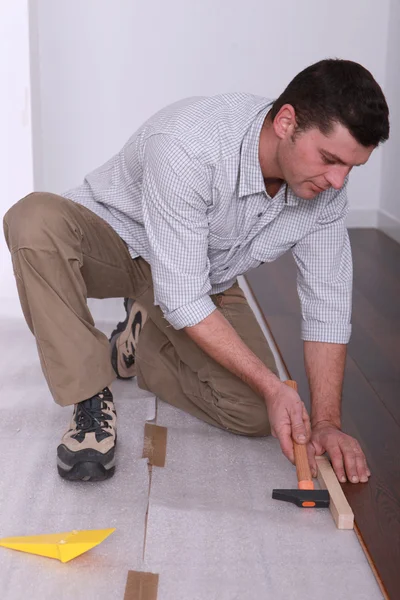 Mann legt einen Holzboden — Stockfoto