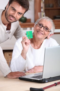 Man helping his mother keep a digital record of her healthcare expenses clipart