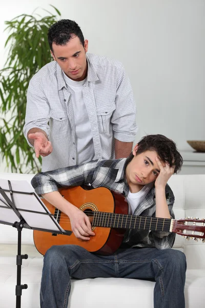 Un padre che insegna a suo figlio a suonare la chitarra . — Foto Stock