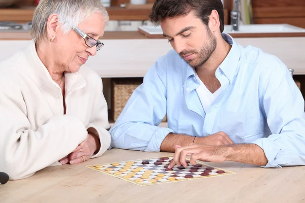 Joven hombre jugando juego con anciana mujer —  Fotos de Stock