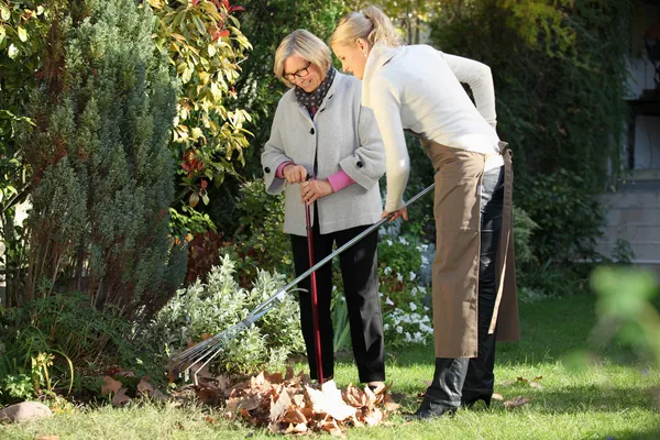 Ηλικιωμένη γυναίκα με την κηπουρός — Φωτογραφία Αρχείου