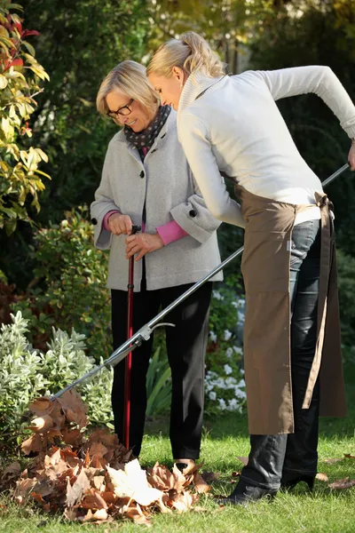 Young woman helping elderly woman to do gardening — Stock Photo, Image
