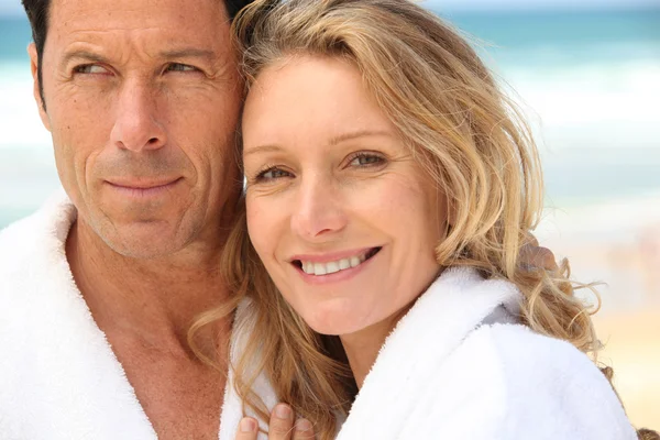 Närbild av ett par på stranden i frotté badrockar — Stockfoto