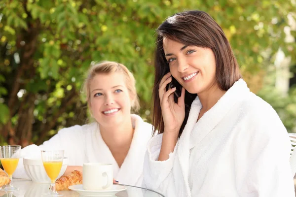 Vrouw op een mobiele telefoon bij het ontbijt — Stockfoto
