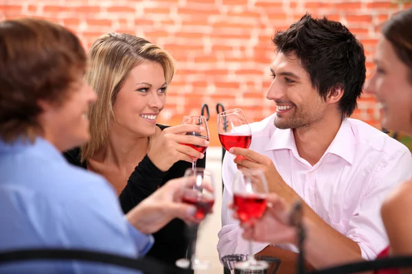 Four friends drinking in restaurant — Stock Photo, Image