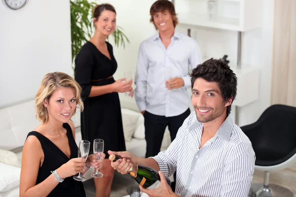 Two well dressed couples drinking sparkling wine in a living room — Stock Photo, Image