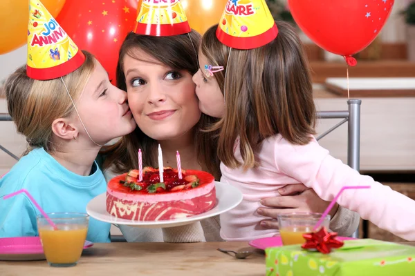 Sisters kissing mom at birthday's party — Stock Photo, Image