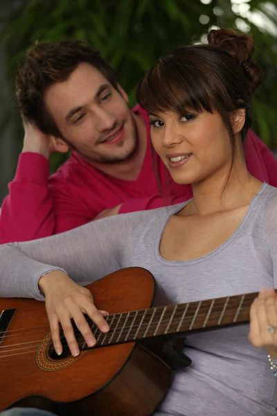 Sorrindo menino e menina tocando guitarra — Fotografia de Stock