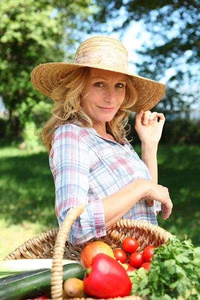 Frau mit Strohhut und Gemüsekorb. — Stockfoto