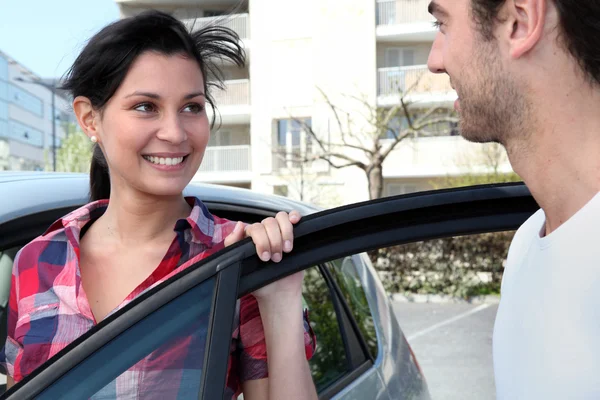 Young couple standing by a car — Stock Photo, Image