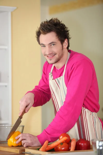 Young man chopping a bell pepper — Stock Photo, Image