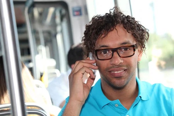 Mężczyzna jazdy tramwaju przy użyciu telefonów komórkowych — Zdjęcie stockowe