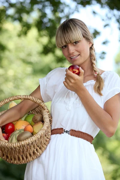 Mulher loira carregando cesta de frutas — Fotografia de Stock