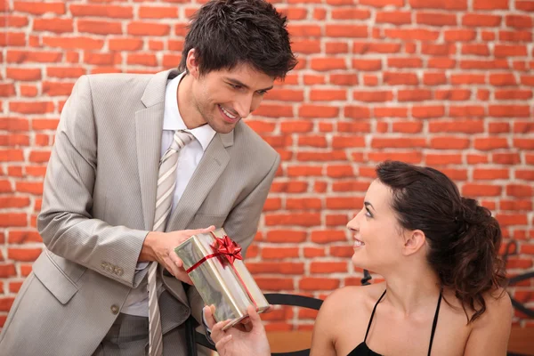 Man offering woman gift in restaurant — Stock Photo, Image