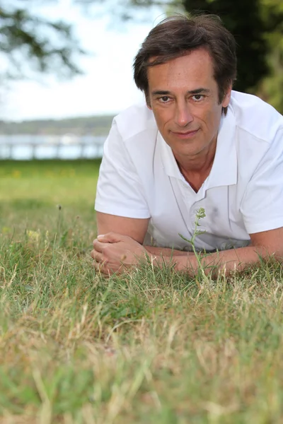 草で横になっている男 — ストック写真