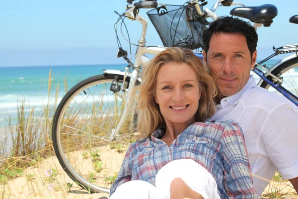 Couple sur la plage avec des vélos — Photo