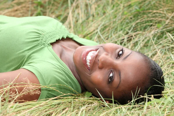긴 잔디에 누워 아름 다운 웃는 여자 — 스톡 사진