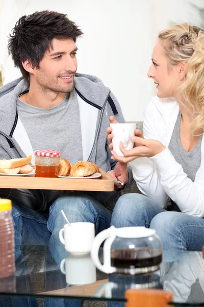 Pareja desayunando juntos en el sofá —  Fotos de Stock