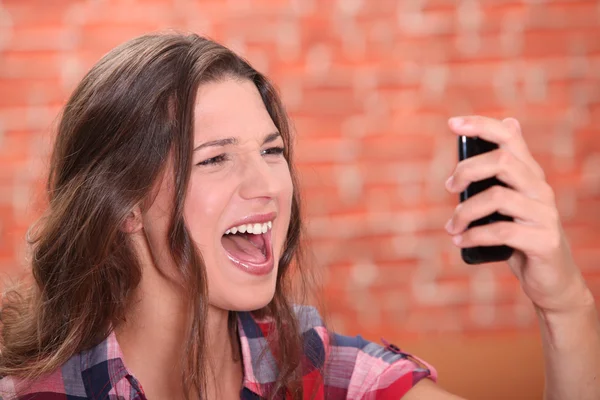 Женщина кричит на свой мобильный телефон — стоковое фото