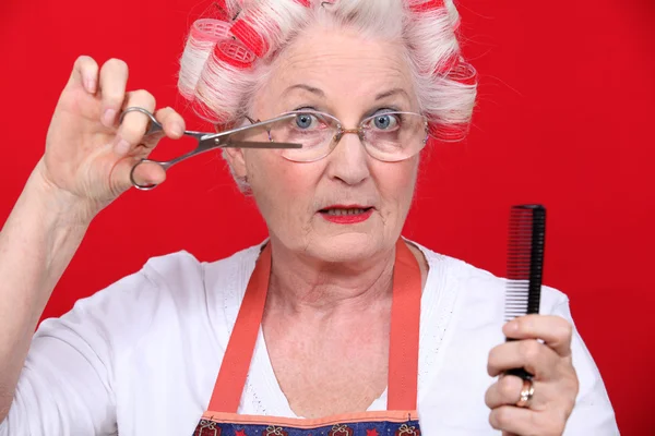Äldre dam styling egna hår — Stockfoto