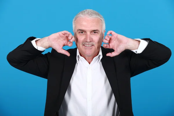 Businessman holding his hands close to his ears — Stock Photo, Image
