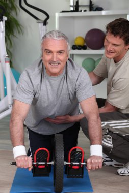 Grey haired man with personal trainer clipart