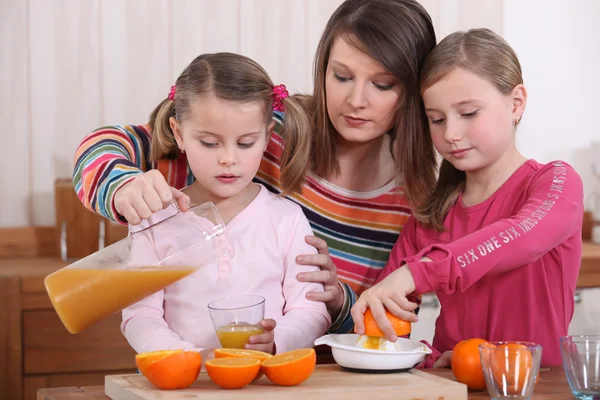 Meninas fazendo suco de laranja — Fotografia de Stock